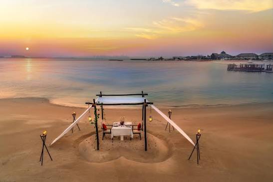 A table set on the sand at sunset